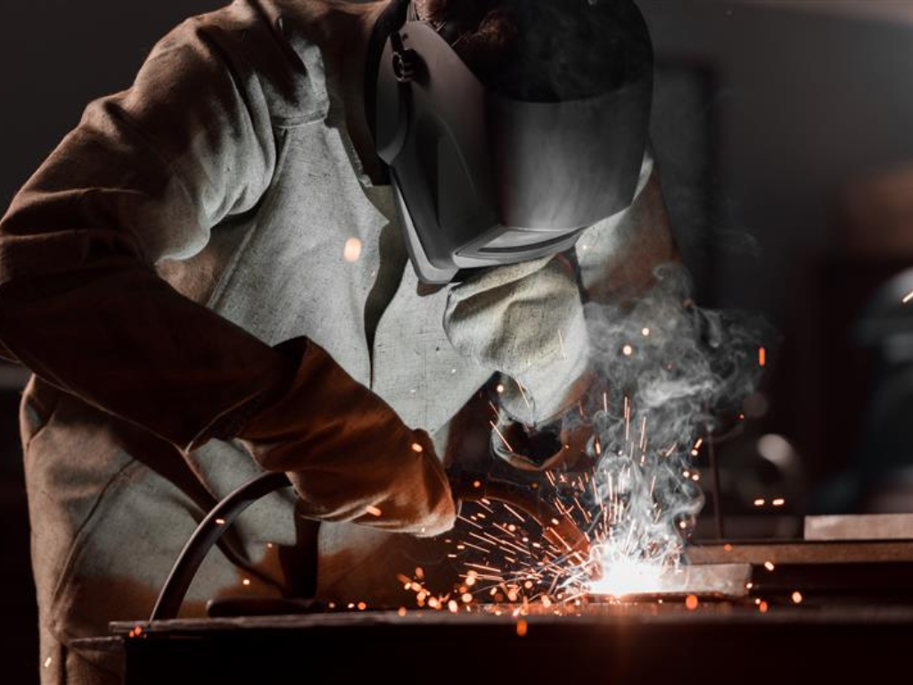 A welder with a protective mask at work, welding